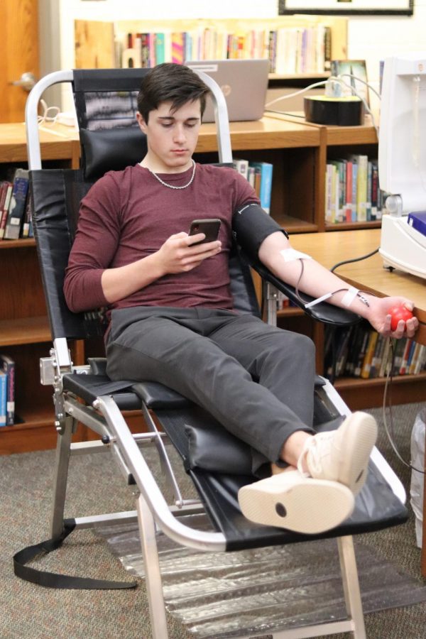 Senior Mason Burrow gives blood during the annual blood drive.