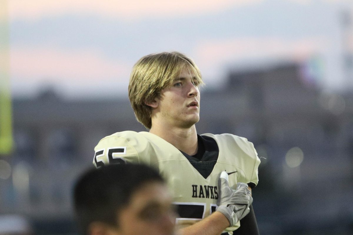 With his hand on his heart, senior Noah Tenny pledges to the American flag before the game.