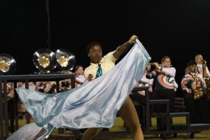 During the halftime show, Khalil Mudrew (9) performs with his flag. 